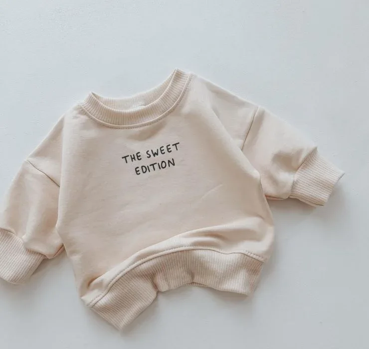 Vorderseite Baby Pullover Vanilla mit dezentem Frontprint The Sweet Edition grau