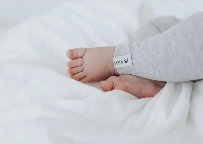 Nahaufnahme der elastischen Ripp-Struktur und J&B Kids Label an der grauen Kinderhose