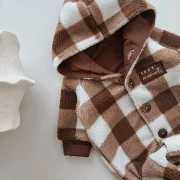 Nahaufnahme Cozy Moments Patch und Kokosknu00f6pfe an Baby Winteroverall