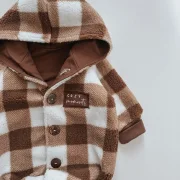 Nahaufnahme Cozy Moments Patch und Kokosknu00f6pfe an Baby Winteroverall