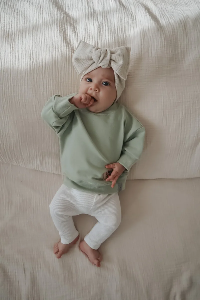 Lu00e4ssiger Baby Pullover in Salbeigru00fcn mit dezenter Front-Applikation handgefertigt