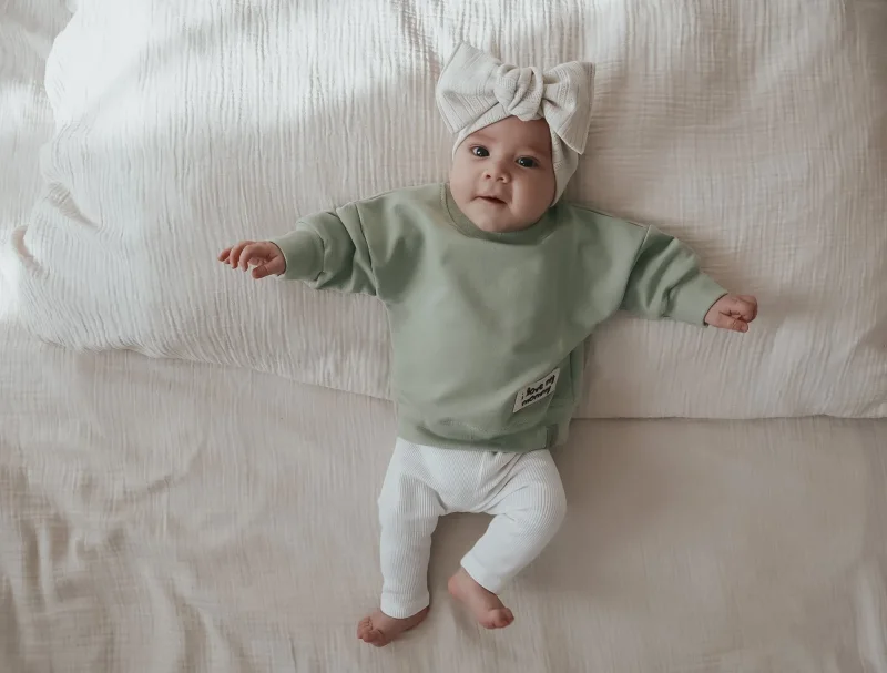 Lu00e4ssiger Baby Pullover in Salbeigru00fcn mit dezenter Front-Applikation handgefertigt