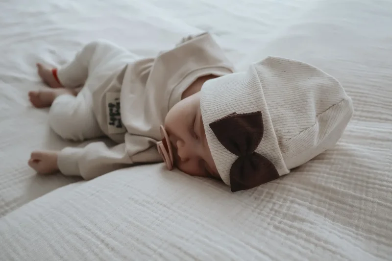 Detailansicht XL Schleife aus Pointelle Jersey auf gerippter Babymütze handgefertigt